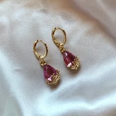 A beautiful pair of either blue or pink glass gem earrings with gold floral detailing. These gems sit on 14k gold filled huggie hoops. This piece comes with a velvet gift bag. Making them ideal as a gift or a treat to yourself.For this piece the huggie hoops are 14k gold filled with a copper core. The hoops use a lever back for closure. The inner diameter of the hoop is 1cm. The gems used in this piece are made of glass and are frame with flowers made with gold plating. Frame With Flowers, Peach Earrings, Blue Or Pink, Gem Earrings, Snake Earrings, Glass Gems, Earring Display, Gold Floral, Crystal Gems