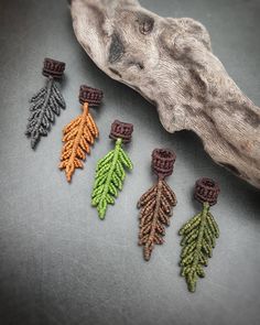 the beaded earrings are made with different colors and shapes, including green, orange, and brown leaves