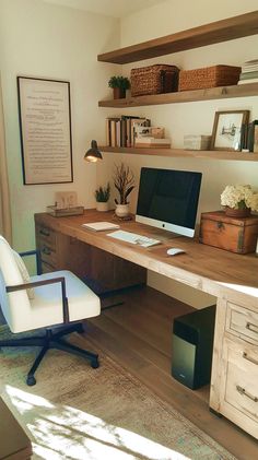 a desk with a computer on top of it in front of a book shelf and window