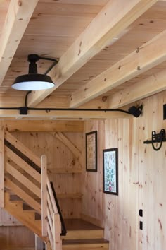 there is a light that is on above the stairs in this house with wood paneling