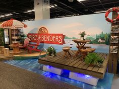 a booth with chairs and tables on the floor in front of a sign that says birch - bender's