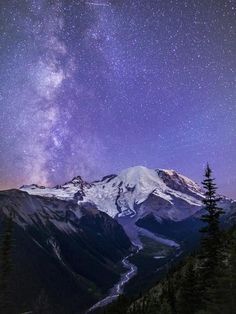 the night sky is filled with stars above mountains and snow capped peaks, as well as milky