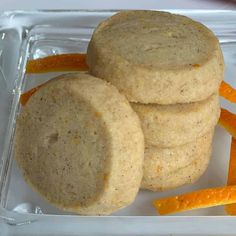 three cookies are stacked on top of each other with orange peels in the background