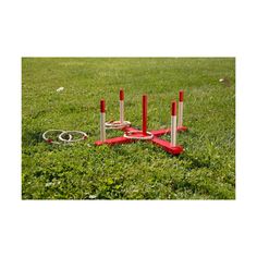 a set of red and white poles in the grass