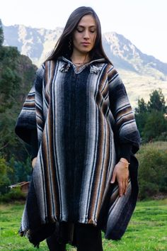 ARRIVES IN 14 DAYS. SHIPPING INCLUDED. This eye-catching unisex poncho with a big hoodie is made of high quality Peruvian sheep wool. It is soft, warm, elegant, ideal for the fall season right around the corner. Perfect for a fall evening at the restaurant, for a walk in nature during the spring season, or just to stay cozy at home. This unique poncho is handmade by local Peruvian artisans in the town of Pisac in the Sacred Valley of Cusco, where we are based. Although alpaca wool is one of the Casual Alpaca Poncho For Fall, Bohemian Long Sleeve Cape For Outdoor, One Size Long Sleeve Poncho For Cold Weather, Casual Alpaca Poncho For Winter, Traditional Black Cape For Fall, Bohemian Long Sleeve Cape For Outdoors, Traditional Winter Poncho For Outdoor, Traditional Oversized Winter Outerwear, Long Sleeve Alpaca Cape For Fall