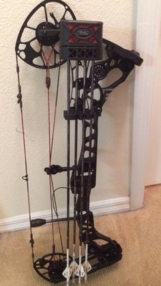 the bow stand is made out of metal and has many different types of arrows attached to it