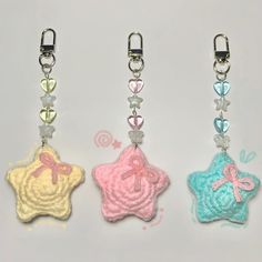 three key chains with different colors and designs on them, one in the shape of a star