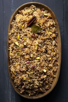 a wooden bowl filled with rice and nuts