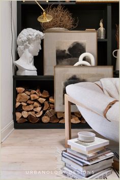 a living room filled with lots of books and art on shelves next to a couch