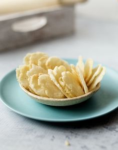 a blue plate topped with chips on top of a table