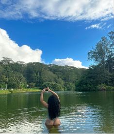 a woman standing in the water taking a photo