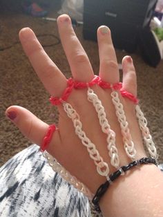 a person wearing bracelets with chains on their hands and red string attached to the wrist