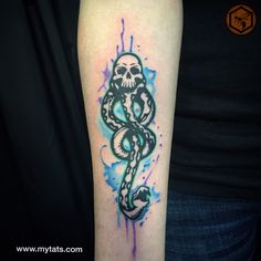 a skull and snake tattoo on the left upper arm with watercolor splatters