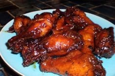 chicken wings covered in bbq sauce on a blue plate