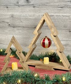 two wooden christmas trees with candles in front of them