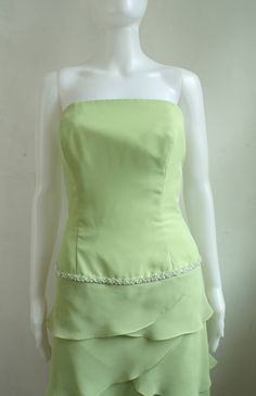 "Pretty cocktail party dress in lime green chiffon. Band of beads and tiered skirt details. Princess seamed bodice with boning to keep dresss in place. Looser cut through hips. Fully lined. condition: excellent color(s): pale green fabric(s): poly chiffon shell / polyester lining brand: none care: dry clean --- measurements --- ✩ size is estimated - please double check measurements for best fit estimated size: xs ✩ all measurements are taken with the item laying flat ✩ bust, waist, and hip measu Green Strapless Dress With Fitted Bodice For Wedding, Tiered Strapless Dress For Summer Wedding, Fitted Strapless Tiered Dress For Prom, Green Strapless Dress With Lined Bodice, Strapless Green Dress With Lined Bodice, Fitted Tiered Strapless Dress For Evening, Spring Wedding Strapless Tiered Dress, Spring Green Strapless Dress With Fitted Bodice, Green Ruffled Strapless Party Dress