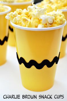 small yellow cups filled with popcorn sitting on top of a table