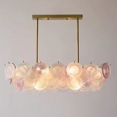 a chandelier made out of glass plates hanging from a brass frame