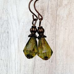 These delightful drop earrings feature faceted Czech glass beads in a mossy olive green with shades of yellow and brown. Brass beads and bead caps top off the look. Inspired by nature, these rustic earrings look great with beige and khaki natural color clothing and add an organic looking touch to your outfit. Custom ear wire style choice at checkout. Hypoallergenic ear wires (nickel and lead free).   Free gift packaging included. Earrings are carded and in an organza bag. Artisan glass beads produced in small quantities in Czech Republic. Link back to my shop: https://www.etsy.com/shop/JezaJewelry Glass Faceted Beads Earrings For Gift, Glass Earrings With Faceted Beads For Gift, Glass Earrings With Faceted Beads As A Gift, Green Teardrop Earrings With Faceted Beads, Rustic Earrings, Glass Drop Earrings, Bronze Earrings, Reno Nv, Brass Beads