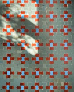 an orange and blue mosaic tile pattern on the side of a building