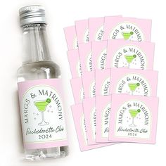 six pink and white labels with a green martini in the middle, sitting next to a bottle of alcohol