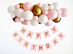 a birthday banner with balloons and streamers in pink, gold and white colors on a white background