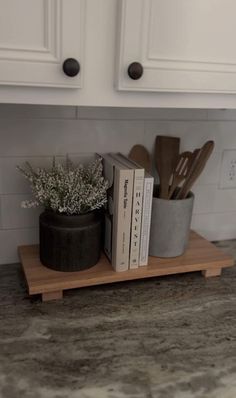 a kitchen counter with some books and utensils on top of the trays