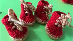 three crocheted baby booties sitting next to each other on a green surface