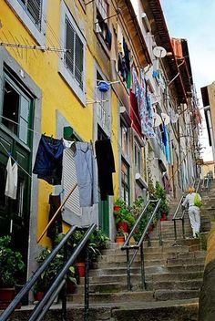 clothes hanging out to dry on the clothesline next to some stairs in an alleyway