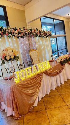 a decorated table with lights and flowers on the top is set up for a formal function