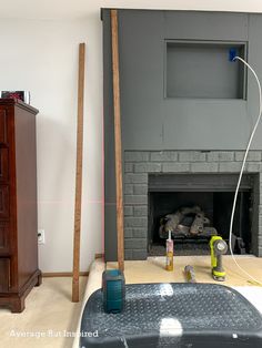 a living room with a fireplace and tools on the floor