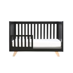 a black crib with white sheets and wooden slats on the bottom, in front of a white background