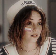 a woman wearing a hat with the flag of iraq painted on her face