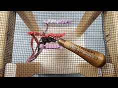 a wooden baseball bat sitting on top of a net next to a piece of cloth