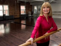 a woman standing in an empty room holding a wooden stick