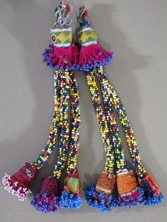 several colorful beads hanging from a hook on a gray wall with shoes and other items