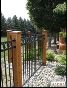 an iron and wood fence in the yard