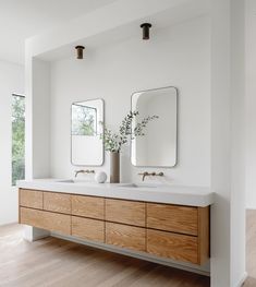 a bathroom with two sinks and mirrors on the wall