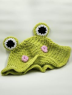 a green crocheted hat with two eyes on it