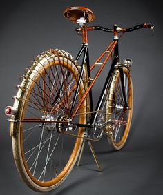 an old fashioned bicycle is on display against a gray background