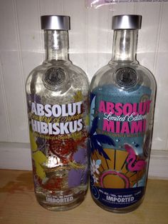 two bottles of absolut vodka sitting next to each other