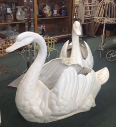 a white swan statue sitting on top of a green floor