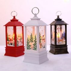 three small lanterns with christmas scenes on them