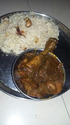 a silver plate topped with rice and meat