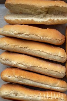 a bunch of hot dogs that are sitting on a table together in a pile with the buns sticking out