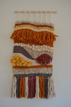 a wall hanging made out of different colored yarns