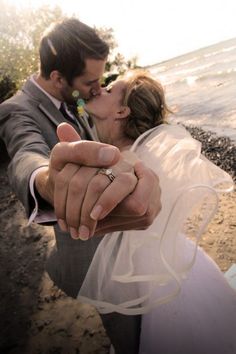 a bride and groom holding each other's hand as they pose for a photo