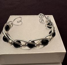 Handmade Hypoallergenic Aluminum Wire Wrapped Obsidian Bead Bracelet. Obsidian (Root Chakra). A Strongly Protective stone, known for its ability to Block, Absorb, and Transform negative energy. Truth-enhancing, Brings clarity to the mind and Clears confusion. Promotes qualities of compassion, strength and increases self-control. Aluminum symbolizes flexibility and versatility due to its malleable nature. This light weight metal will never tarnish or discolor. It is also hypoallergenic.and does not cause skin allergies. Makes a wonderful Valentine's Day Gift, Mother's Day Gift, or maybe even a Gift for yourself! Gift for any occasion, JUST BECAUSE - GIFTS OF LOVE! CARE INSTRUCTIONS: I recommend not wearing while exercising, showering or swimming. Use warm soapy water to clean then dry with Onyx Bead Jewelry As Gift, Onyx Bead Jewelry Gift, Onyx Beads Jewelry Gift, Modern Onyx Bracelets For Gift, Modern Onyx Bracelets For Gifts, Modern Onyx Bracelets As Gift, Wire Wrapped Bracelets As A Gift, Wire Wrapped Bracelets With Round Beads As Gift, Handmade Black Crystal Bracelet As Gift