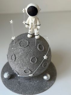 an astronaut is standing on top of a rock with stars and moon decorations around it