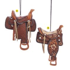 two brown and white horse saddles hanging from strings